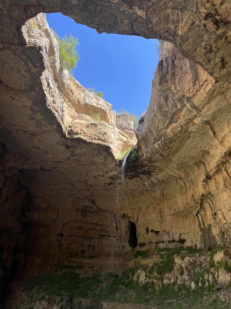 Waterfall descending through the limestone arches of Baatra Gorge